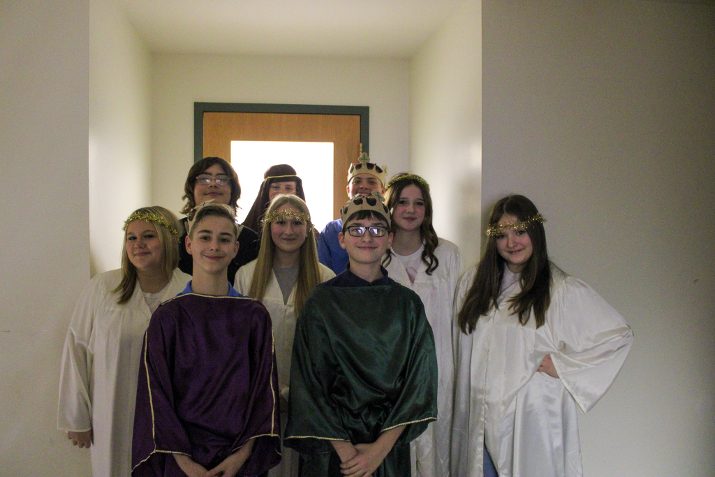 group picture of the upperclassmen standing backstage during school Christmas program