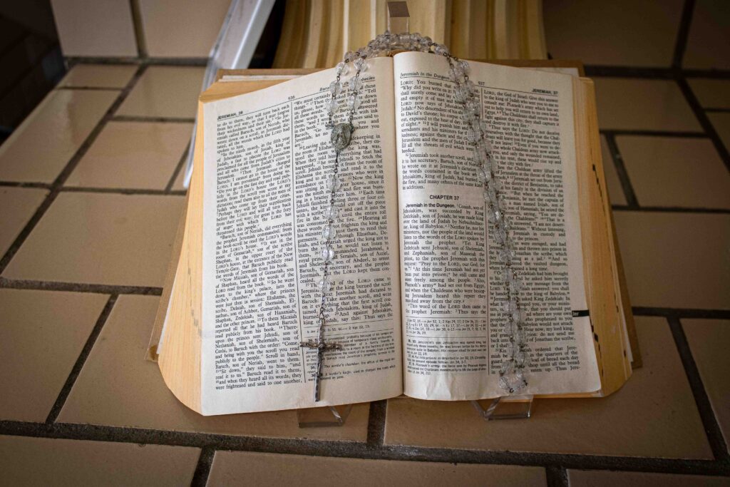 Bible displayed openly with a rosary strung on the bible