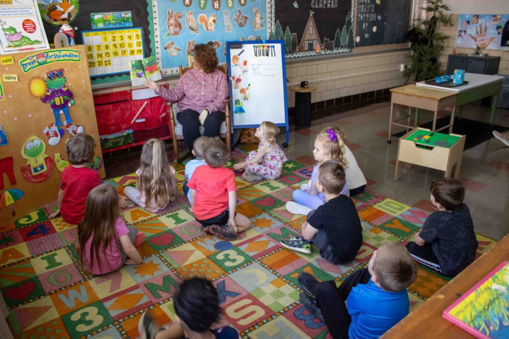 Preschoolers enjoying reading class, with a fun book being read by Ms. Knight
