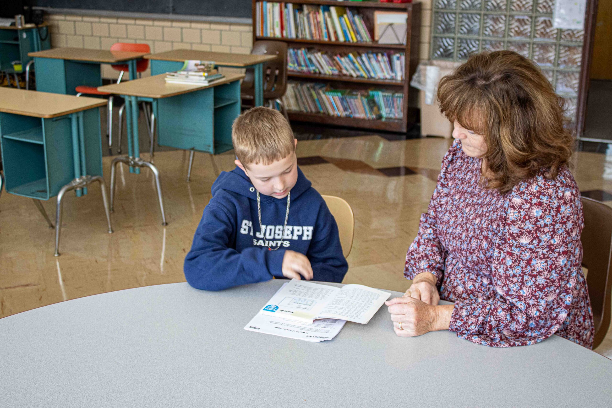 Student working one on one with a teacher to learn during school
