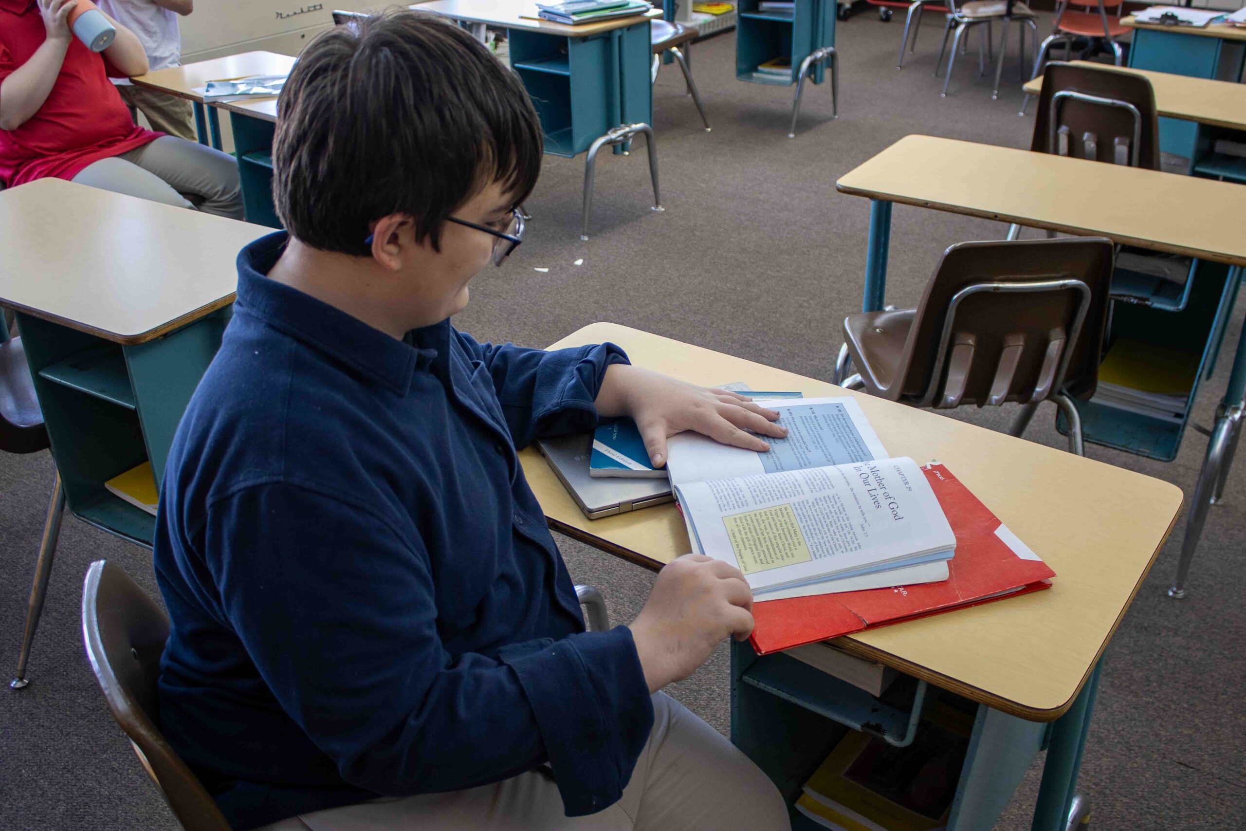 Student reading a book about the Mother of God: Mary during religion class